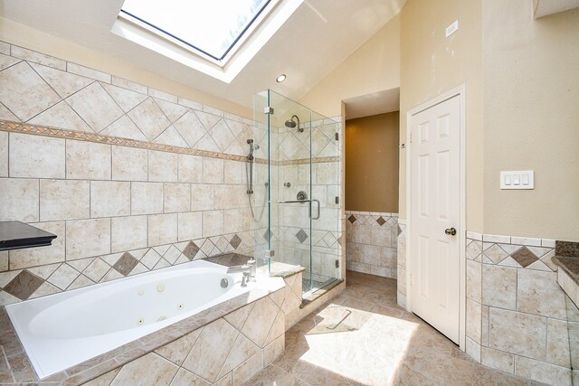 16323 Elmwood Point Ln, Sugar Land, TX 77498 - bathroom with tile walls, a skylight, a whirlpool tub, a stall shower, and vaulted ceiling