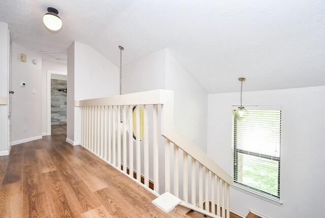 16323 Elmwood Point Ln, Sugar Land, TX 77498 - corridor with an upstairs landing, wood finished floors, vaulted ceiling, a textured ceiling, and baseboards