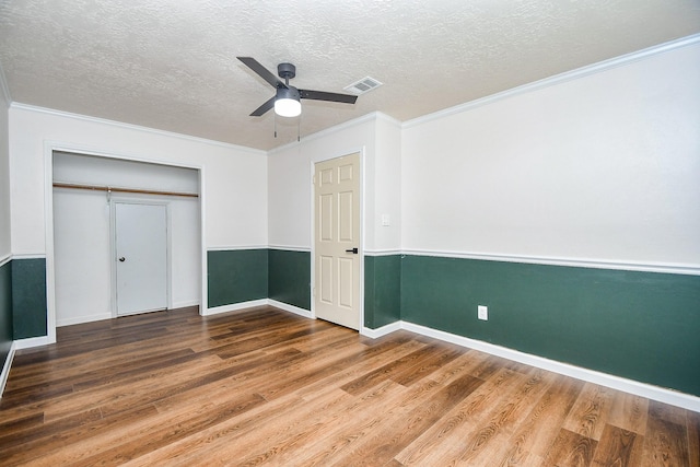 16323 Elmwood Point Ln, Sugar Land, TX 77498 - unfurnished bedroom with wood finished floors, a textured ceiling, a closet, crown molding, and baseboards