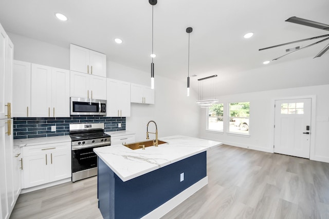 9406 Sandra St, Houston, TX 77016 - kitchen with appliances with stainless steel finishes, light wood-style flooring, decorative backsplash, white cabinetry, and light stone counters
