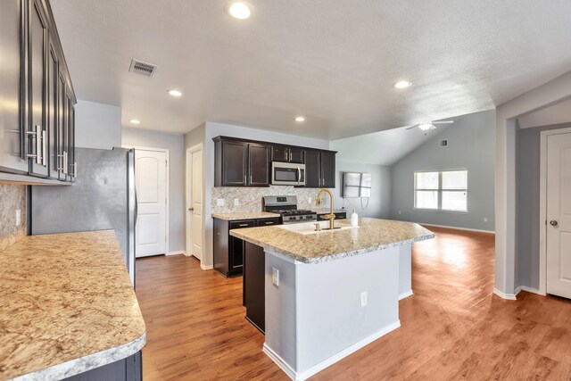 16531 Silla Ridge Ct, Houston, TX 77049 - kitchen featuring appliances with stainless steel finishes, a sink, decorative backsplash, baseboards, and light wood finished floors