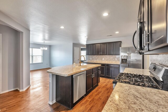 16531 Silla Ridge Ct, Houston, TX 77049 - kitchen featuring a sink, stainless steel appliances, a chandelier, tasteful backsplash, and a center island with sink
