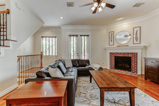 1529 Rosewood St, Houston, TX 77004 - living area with a ceiling fan, light wood-type flooring, crown molding, baseboards, and a brick fireplace
