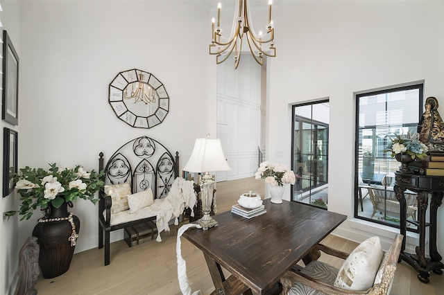 11303 Flying Admiral Dr, Cypress, TX 77433 - dining area with light wood-style floors, a chandelier, a towering ceiling, and baseboards