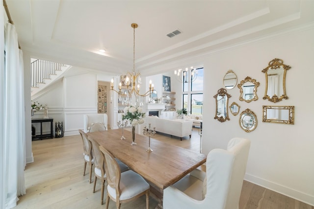 11303 Flying Admiral Dr, Cypress, TX 77433 - dining room with a raised ceiling, a chandelier, light wood-style floors, stairs, and crown molding