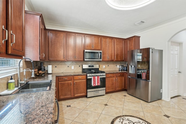 14 Carmel Chase Ct, Manvel, TX 77578 - kitchen with appliances with stainless steel finishes, a sink, arched walkways, decorative backsplash, and crown molding