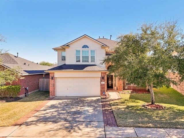 14 Carmel Chase Ct, Manvel, TX 77578 - traditional-style house featuring an attached garage, driveway, brick siding, and a shingled roof