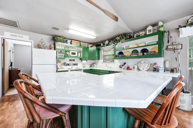 134 Private Road 652, Sargent, TX 77414 - kitchen with white appliances, tile countertops, open shelves, light wood-style flooring, and lofted ceiling