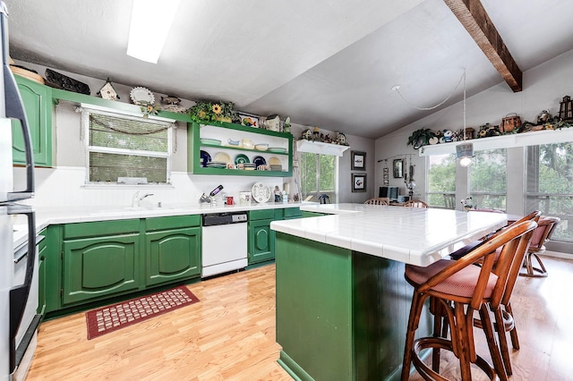 134 Private Road 652, Sargent, TX 77414 - kitchen with white dishwasher, green cabinetry, light wood finished floors, tile counters, and a kitchen breakfast bar