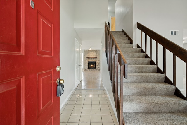 12115 Essenbruk Dr, Houston, TX 77066 - foyer entrance featuring light tile patterned floors, a fireplace, stairs, and baseboards