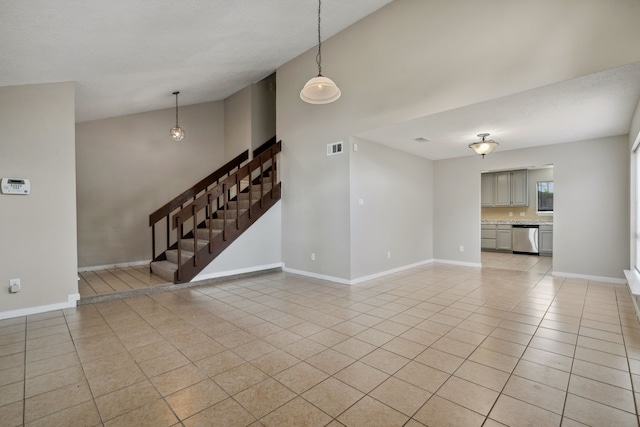 12115 Essenbruk Dr, Houston, TX 77066 - unfurnished living room featuring light tile patterned flooring, high vaulted ceiling, stairs, and baseboards