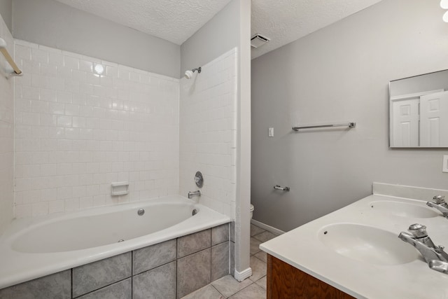 12115 Essenbruk Dr, Houston, TX 77066 - bathroom with tile patterned floors, double vanity, tiled shower / bath combo, toilet, and a textured ceiling