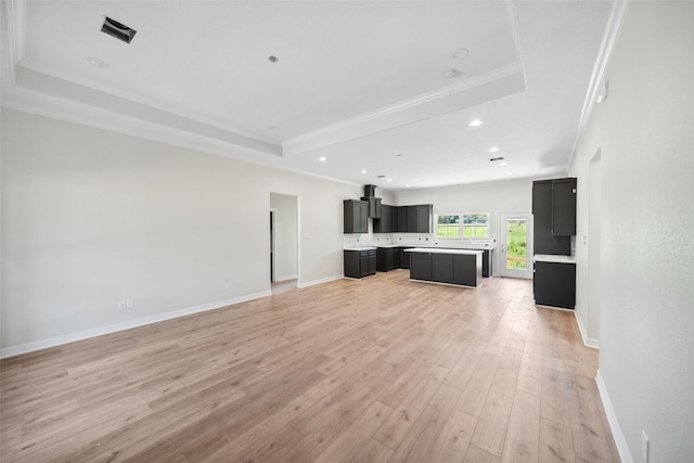190 Faulkner Ave, Coldspring, TX 77331 - unfurnished living room with a raised ceiling, light wood-type flooring, recessed lighting, baseboards, and crown molding