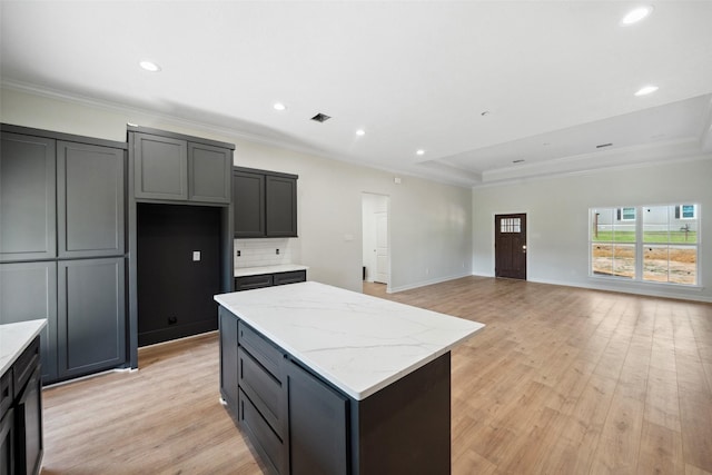 190 Faulkner Ave, Coldspring, TX 77331 - kitchen featuring a kitchen island, ornamental molding, light wood-style floors, decorative backsplash, and light stone countertops