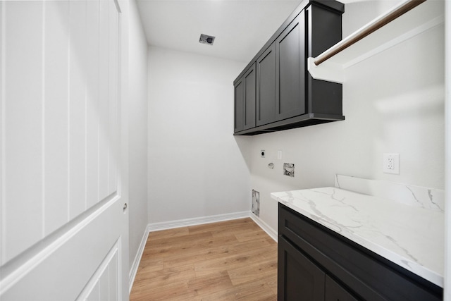 190 Faulkner Ave, Coldspring, TX 77331 - washroom featuring electric dryer hookup, cabinet space, light wood-style floors, baseboards, and gas dryer hookup