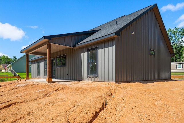 190 Faulkner Ave, Coldspring, TX 77331 - view of side of property with roof with shingles, board and batten siding, and a patio