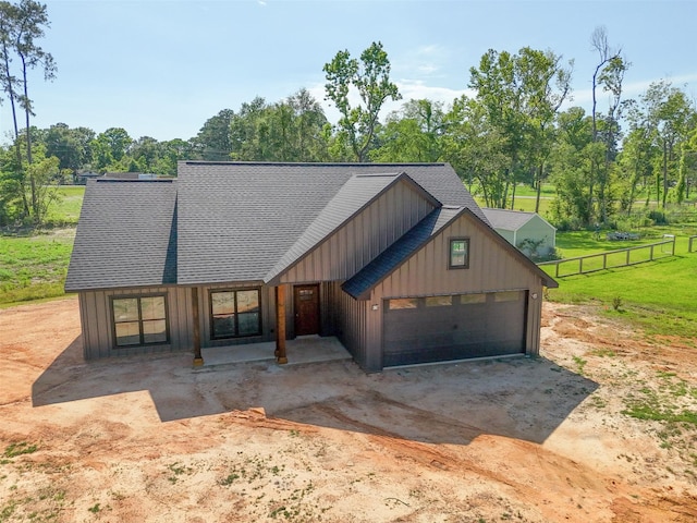 190 Faulkner Ave, Coldspring, TX 77331 - view of front facade featuring board and batten siding, a shingled roof, view of wooded area, an attached garage, and driveway
