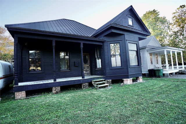 2215 Kane St, Houston, TX 77007 - rear view of house featuring covered porch, a yard, metal roof, and a standing seam roof