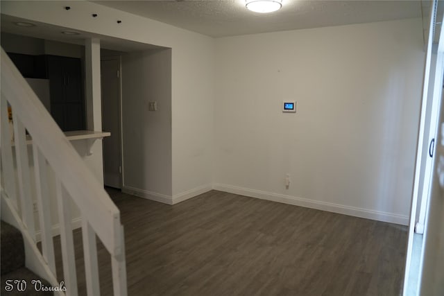 8803 Vinkins Rd, Houston, TX 77071 - spare room with dark wood-style flooring, stairs, baseboards, and a textured ceiling