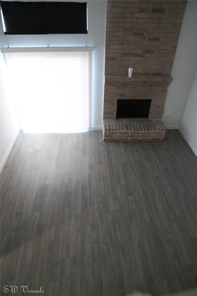 8803 Vinkins Rd, Houston, TX 77071 - unfurnished living room featuring wood finished floors, baseboards, and a brick fireplace