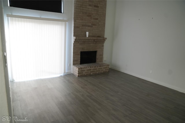 8803 Vinkins Rd, Houston, TX 77071 - unfurnished living room with wood finished floors, a brick fireplace, and baseboards