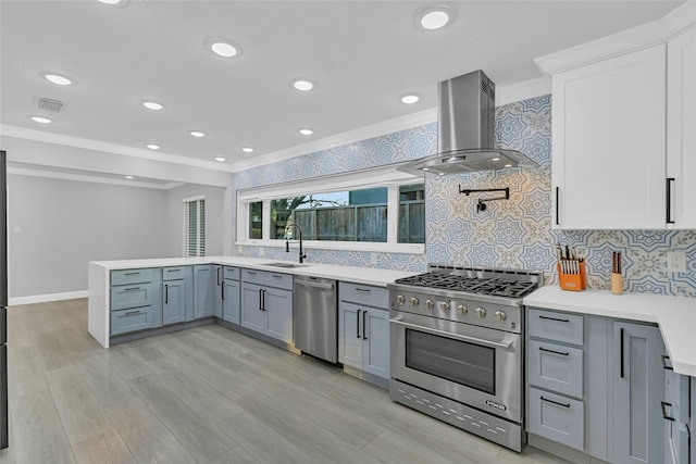 5122 Braesheather Dr, Houston, TX 77096 - kitchen with appliances with stainless steel finishes, island range hood, a sink, light countertops, and tasteful backsplash