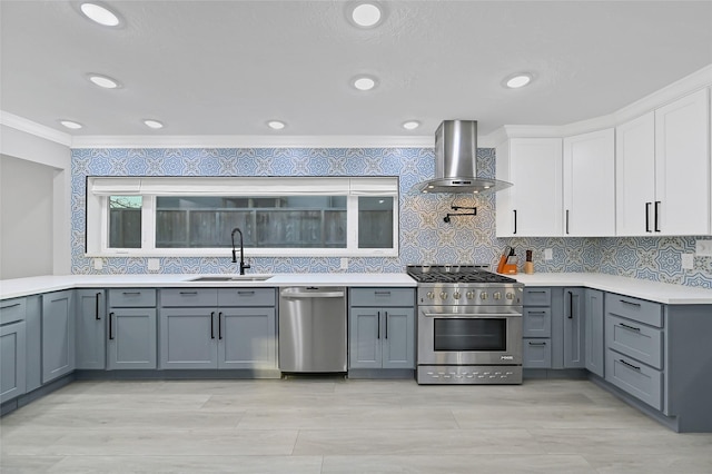 5122 Braesheather Dr, Houston, TX 77096 - kitchen with appliances with stainless steel finishes, wall chimney range hood, a sink, crown molding, and light countertops