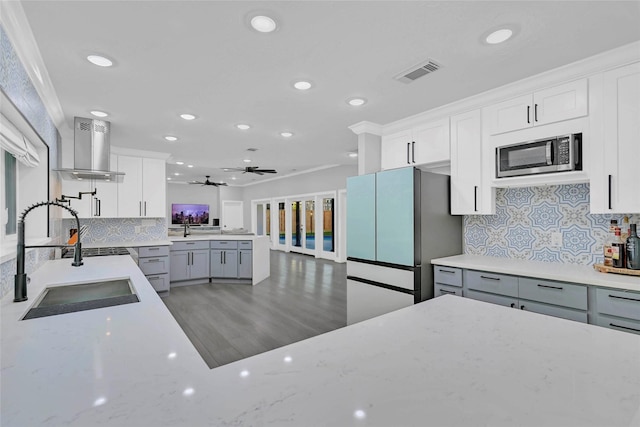 5122 Braesheather Dr, Houston, TX 77096 - kitchen with island exhaust hood, stainless steel microwave, a sink, recessed lighting, and decorative backsplash