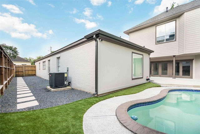 5122 Braesheather Dr, Houston, TX 77096 - back of house with central AC unit, a fenced backyard, a patio, an outdoor pool, and brick siding