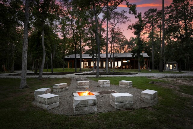 17131 Carrol Ln, Willis, TX 77378 - surrounding community with an outdoor fire pit, a lawn, and an outdoor structure