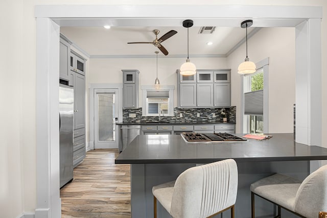 826 Omar St, Houston, TX 77009 - kitchen featuring dark countertops, appliances with stainless steel finishes, ceiling fan, a kitchen breakfast bar, and a peninsula