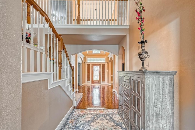 13311 Barbstone Dr, Houston, TX 77044 - entrance foyer with arched walkways, wood finished floors, stairs, baseboards, and a high ceiling