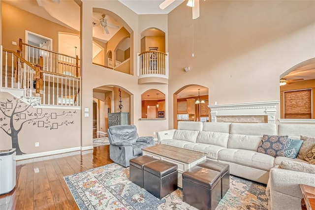 13311 Barbstone Dr, Houston, TX 77044 - living area featuring a ceiling fan, a high ceiling, baseboards, and arched walkways