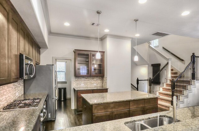 4247 Dickson St, Houston, TX 77007 - kitchen with appliances with stainless steel finishes, a center island, dark wood-style flooring, decorative backsplash, and recessed lighting
