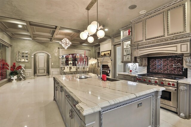 17122 Ashley Woods Ct, Spring, TX 77379 - kitchen with designer range, a chandelier, arched walkways, coffered ceiling, and gray cabinetry