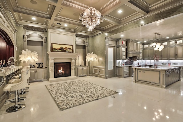 17122 Ashley Woods Ct, Spring, TX 77379 - kitchen featuring ornamental molding, coffered ceiling, glass insert cabinets, a kitchen island with sink, and a warm lit fireplace