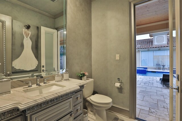 17122 Ashley Woods Ct, Spring, TX 77379 - bathroom featuring stone tile flooring, vanity, toilet, and crown molding