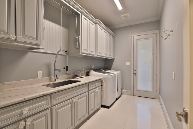 17122 Ashley Woods Ct, Spring, TX 77379 - laundry area with cabinet space, washing machine and dryer, crown molding, baseboards, and light tile patterned floors