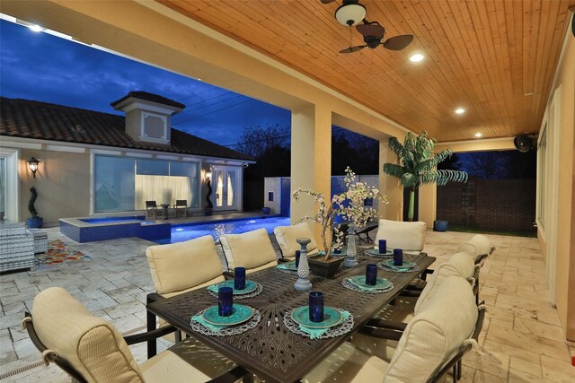 17122 Ashley Woods Ct, Spring, TX 77379 - patio at twilight featuring a patio, outdoor dining area, a pool with connected hot tub, and a ceiling fan