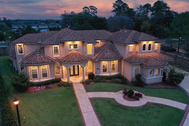 17122 Ashley Woods Ct, Spring, TX 77379 - mediterranean / spanish-style home featuring a tile roof, stucco siding, a front yard, and covered porch