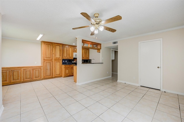 12028 Mighty Oak Dr Unit A, Houston, TX 77066 - kitchen with ceiling fan, ornamental molding, dark countertops, brown cabinetry, and white microwave