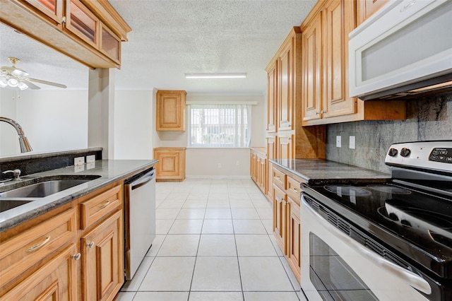 12028 Mighty Oak Dr Unit A, Houston, TX 77066 - kitchen with stainless steel appliances, a sink, decorative backsplash, light tile patterned flooring, and a textured ceiling