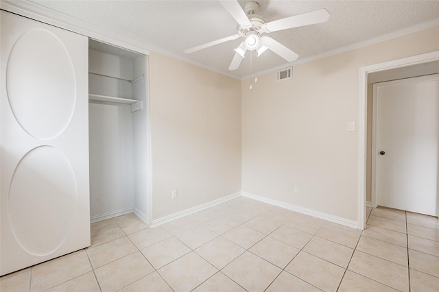 12028 Mighty Oak Dr Unit A, Houston, TX 77066 - unfurnished bedroom with light tile patterned floors, a closet, a textured ceiling, a ceiling fan, and ornamental molding
