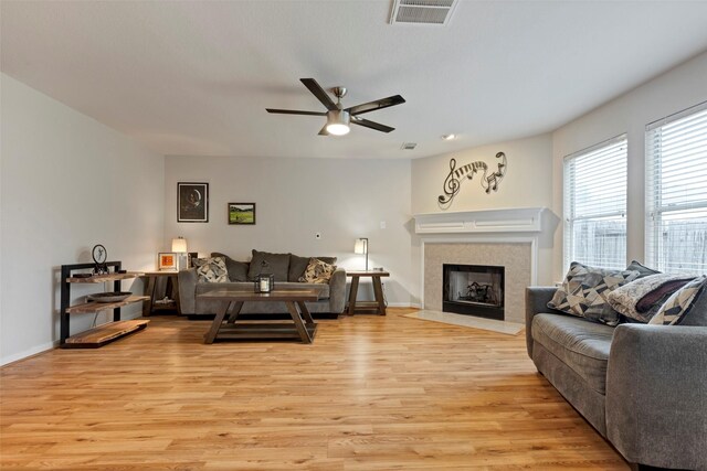 25430 Twister Trl, Spring, TX 77373 - living area with light wood-style flooring, ceiling fan, a fireplace with flush hearth, and baseboards