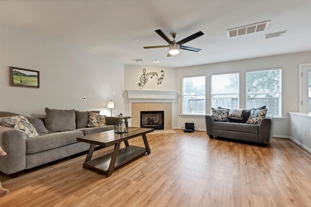 25430 Twister Trl, Spring, TX 77373 - living area featuring ceiling fan, light wood finished floors, a tile fireplace, and baseboards