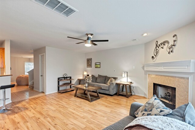 25430 Twister Trl, Spring, TX 77373 - living area featuring light wood-style floors, ceiling fan, a fireplace, and baseboards