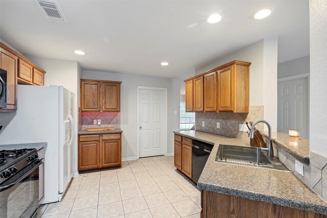 25430 Twister Trl, Spring, TX 77373 - kitchen with black appliances, a sink, a peninsula, backsplash, and recessed lighting