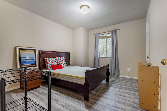 14639 Cypress Cottage Ct, Cypress, TX 77429 - bedroom featuring wood finished floors, baseboards, and a textured ceiling