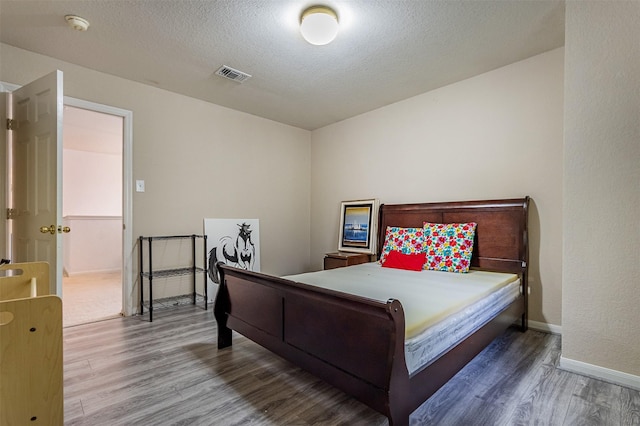 14639 Cypress Cottage Ct, Cypress, TX 77429 - bedroom with wood finished floors, baseboards, and a textured ceiling