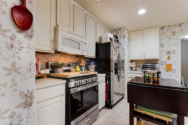 14639 Cypress Cottage Ct, Cypress, TX 77429 - kitchen with appliances with stainless steel finishes, wallpapered walls, light tile patterned floors, backsplash, and recessed lighting